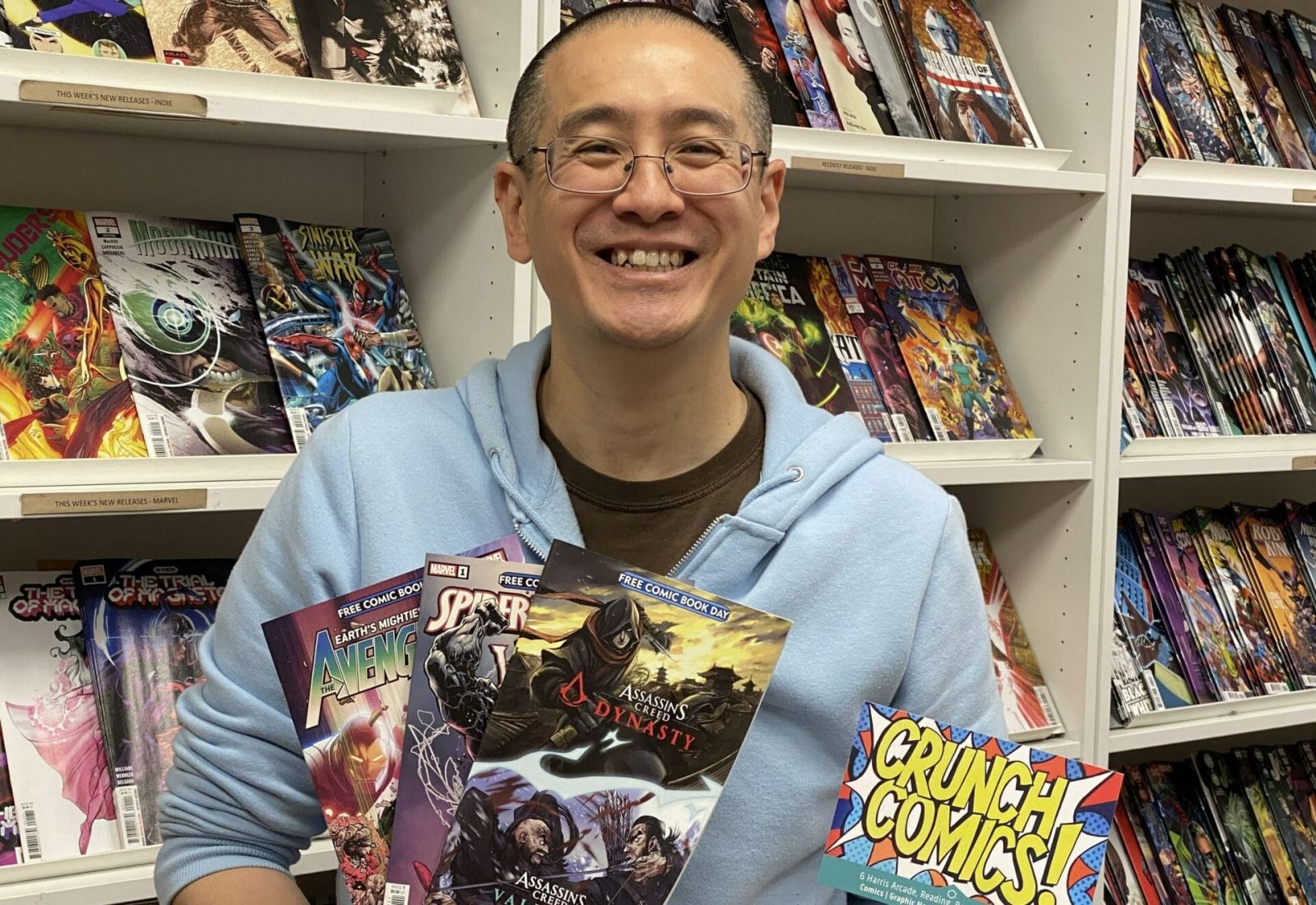 Manager, Brian holding comics in the store